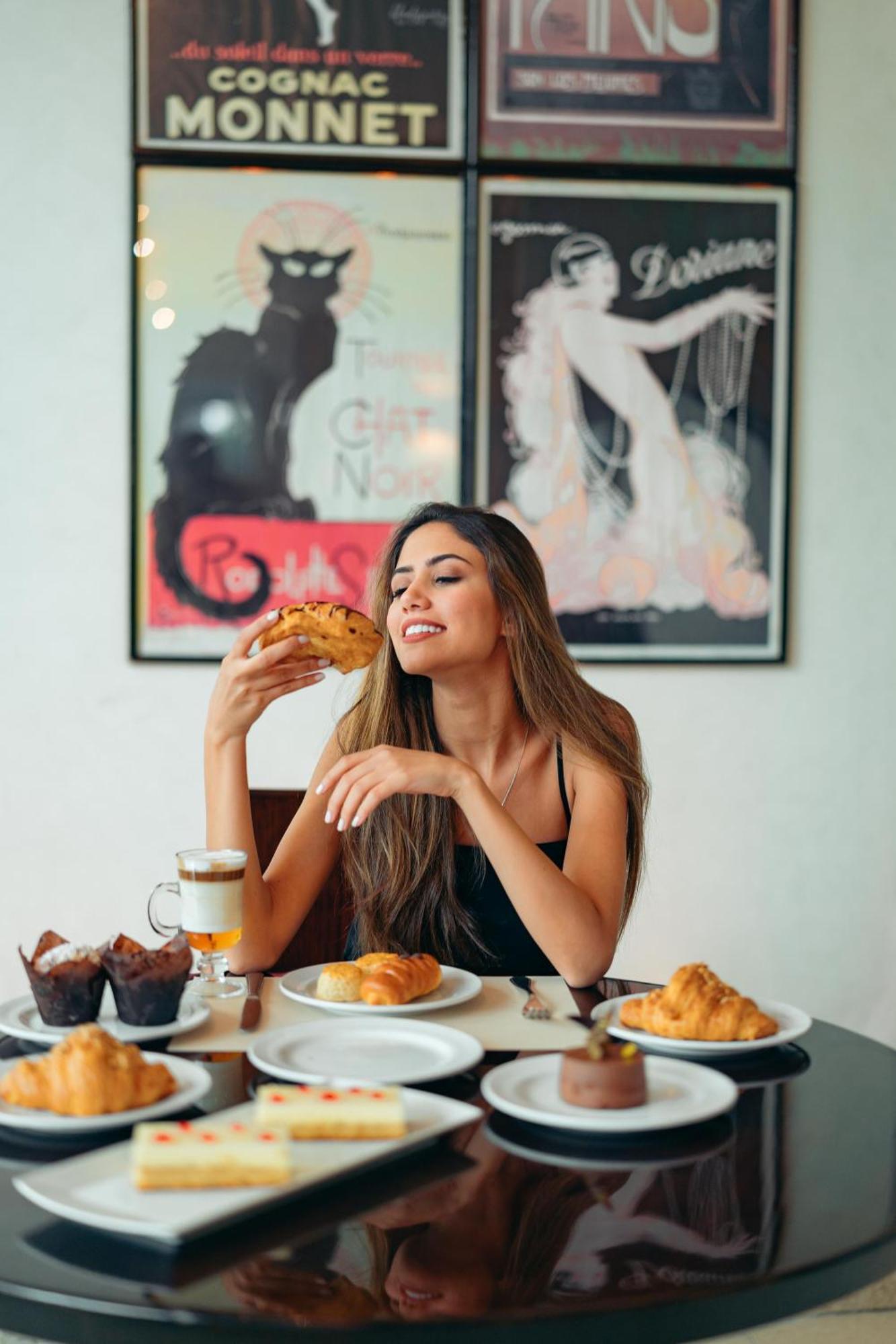 Hilton Cairo Heliopolis Hotel Bagian luar foto A woman eating a pastry
